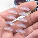 GMS Optical Contour Silicone Nose Pads 18mm Clear in Person's Hand