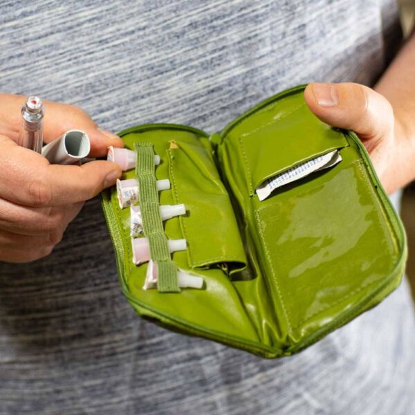 Man holding Green Dittibag open filled with insulin