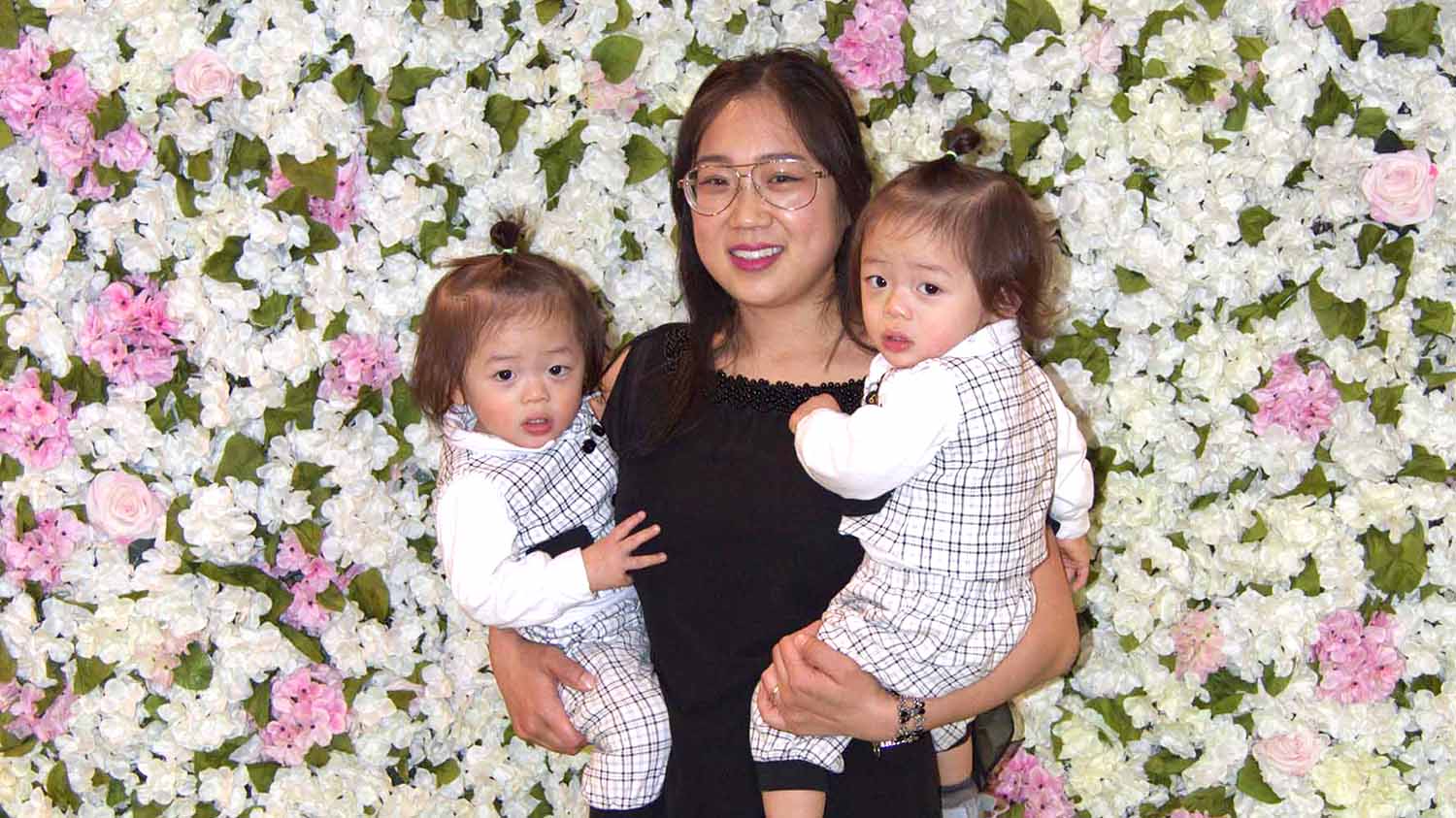 Michelle holding her twin boys at a work event